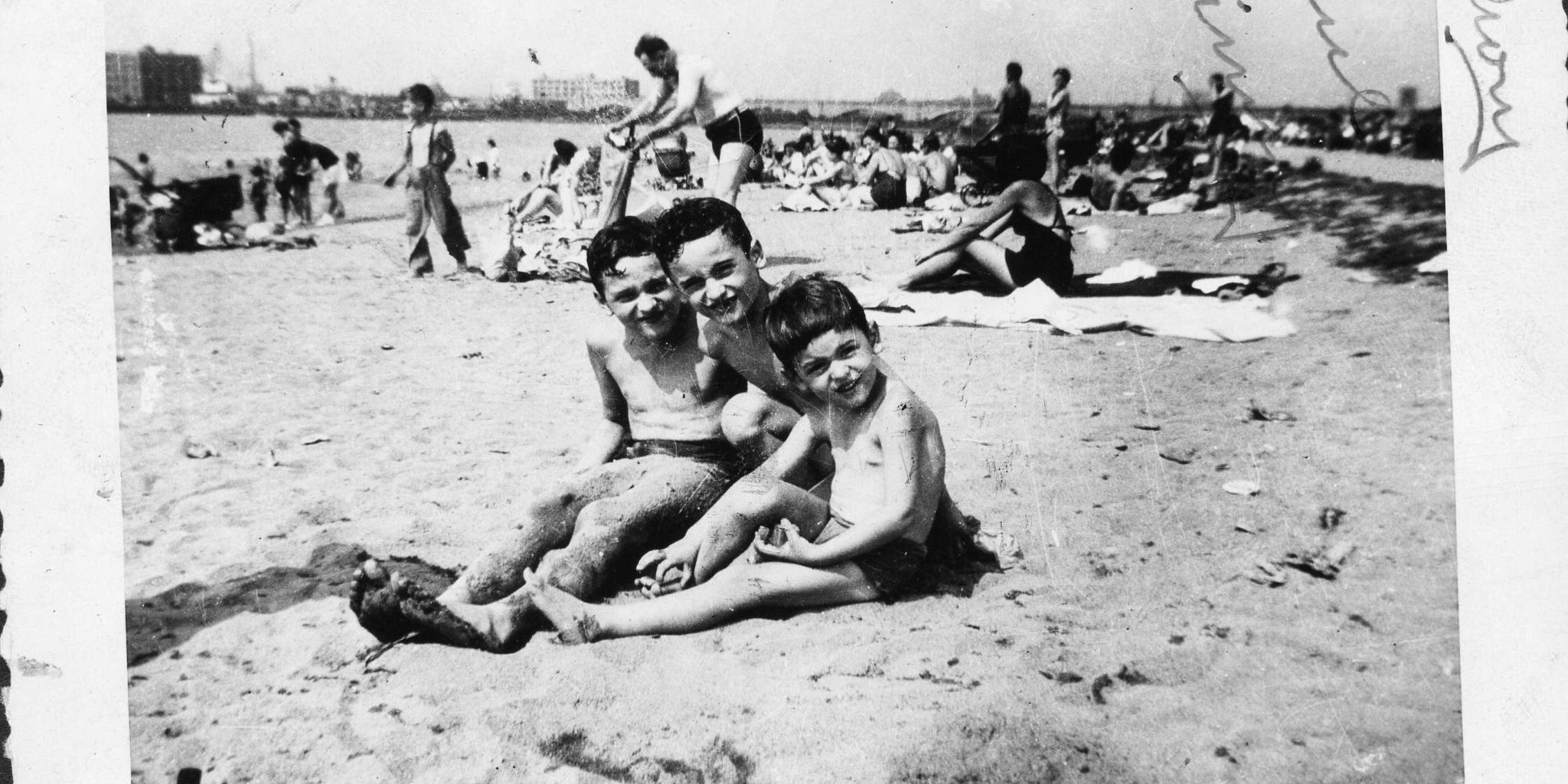 3 boys sitting on the beach