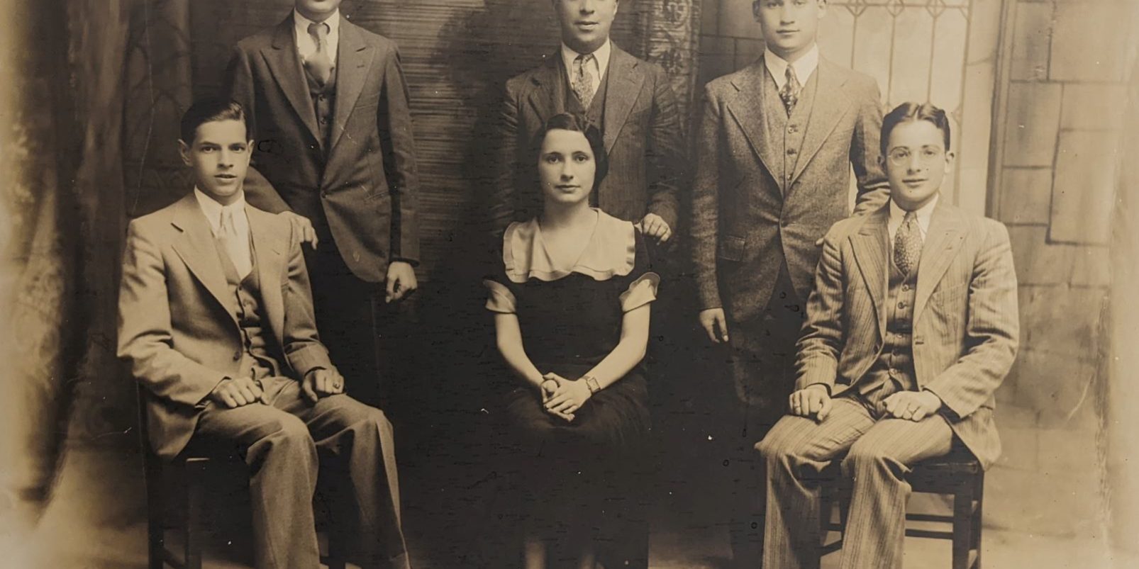 Six persons sitting in 2 rows with a woman in the front center