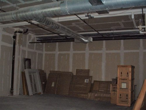 A bare room, unpainted, with boxes along the wall