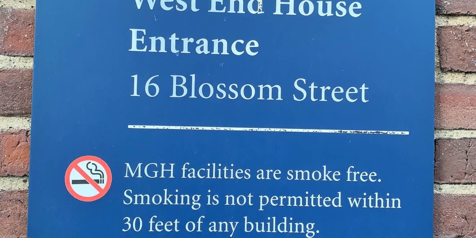A blue sign reading West End House Entrance