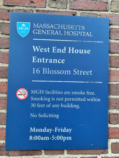 A blue sign reading West End House Entrance