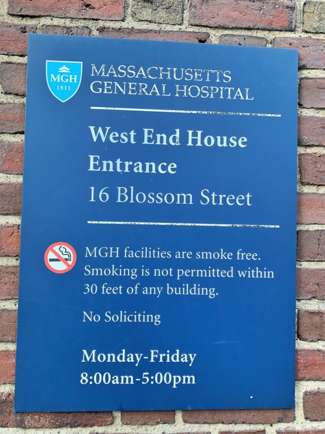 A blue sign reading West End House Entrance