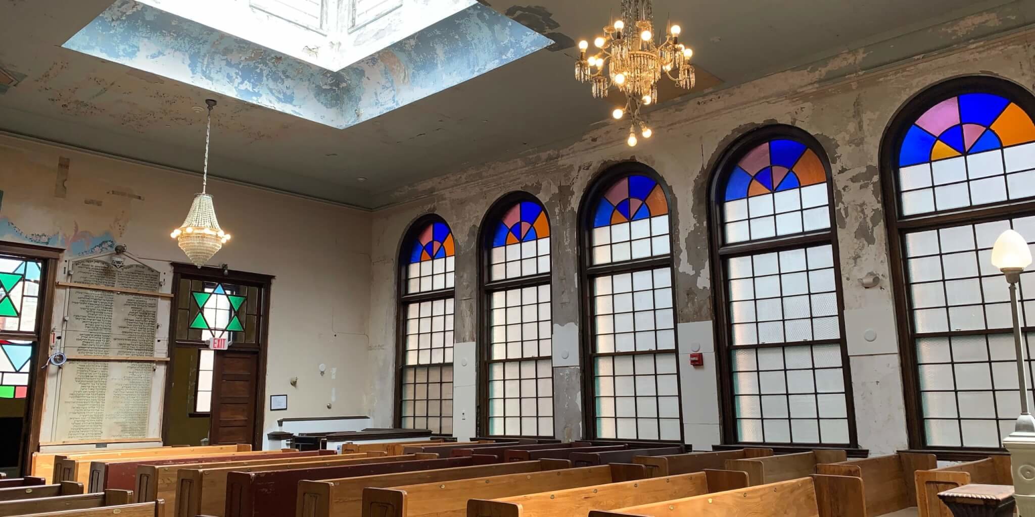 The sanctuary with original pews from a neighborhood church A sanctuary with crumbling plaster walls and chipped paint