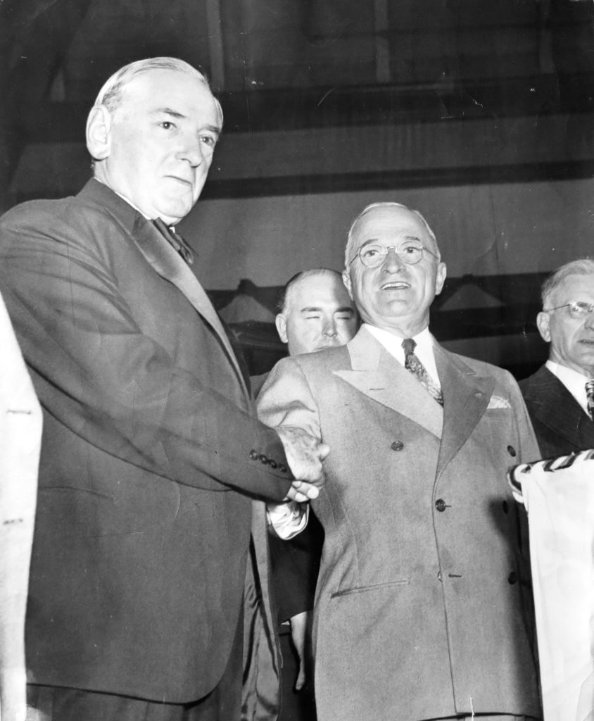 Two men (James Michael Curley and President Truman) in suits shaking hands