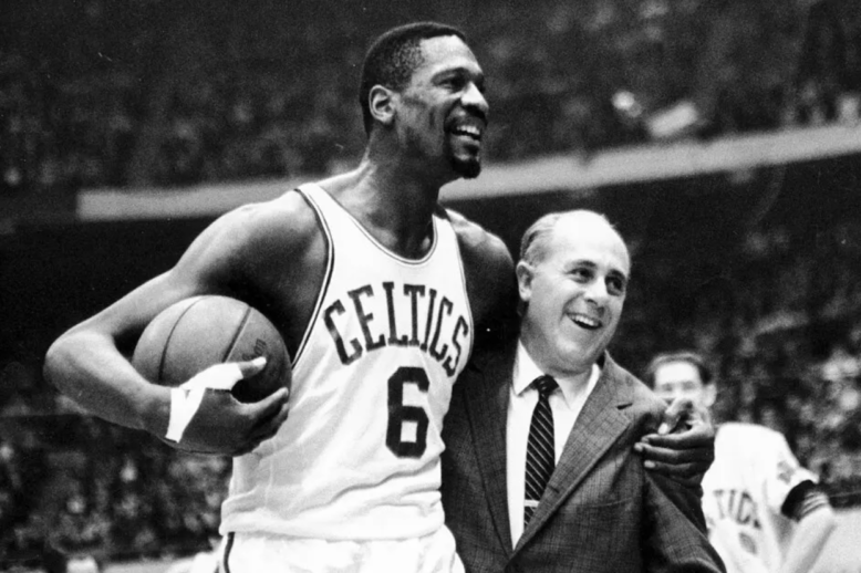 A basketball player with his arm around his coach, both are smiling