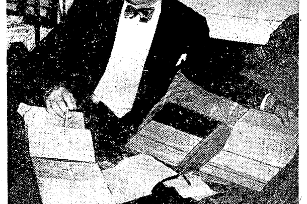 A man sits reclines wearing a tuxedo and bowtie