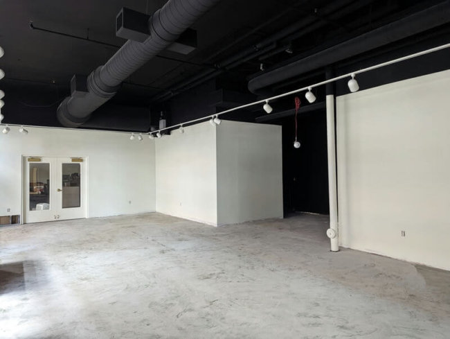 A room with fresh paint and a unfinished cement floor