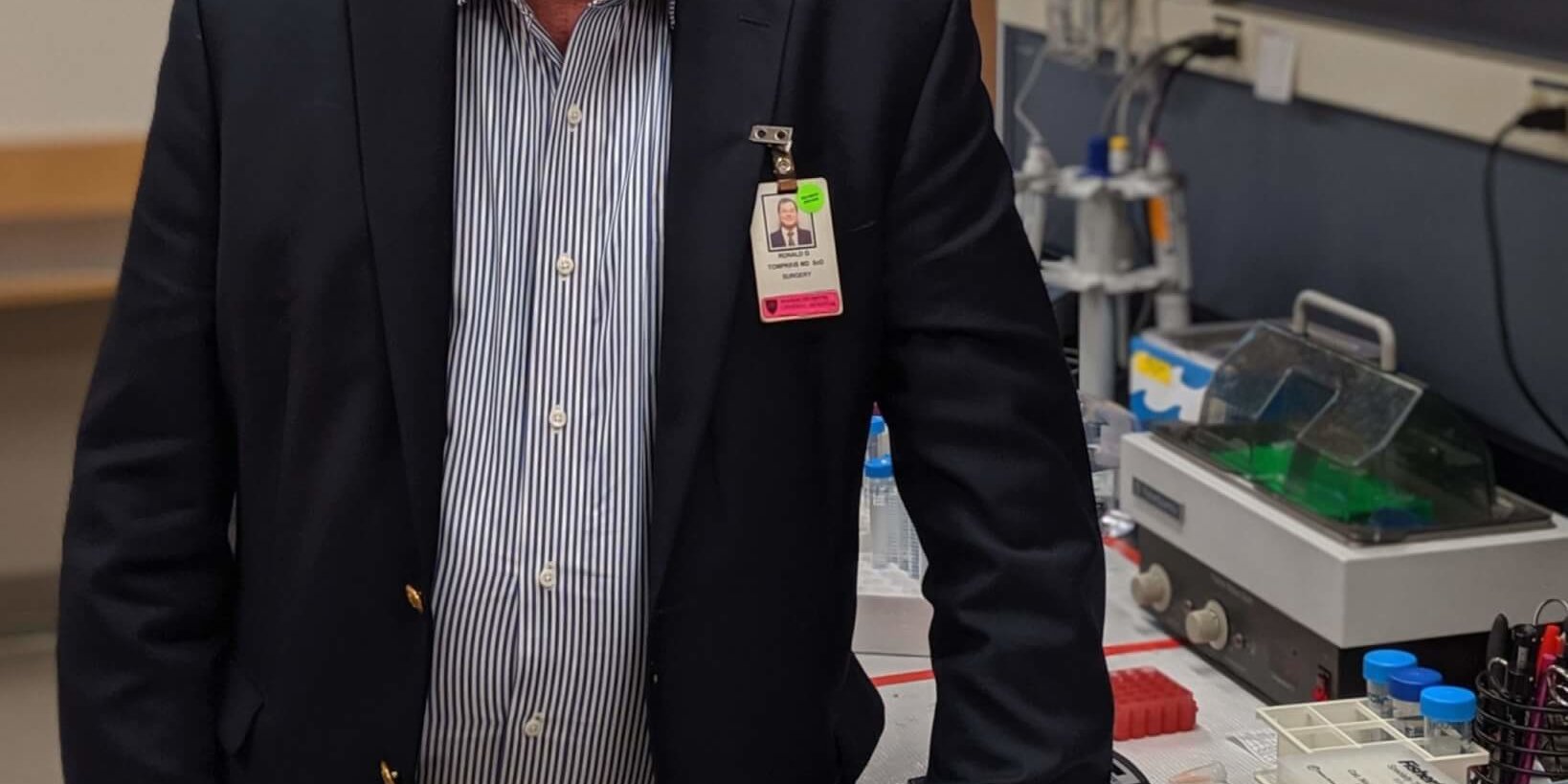 A man in his sixties standing in a medical laboratory.