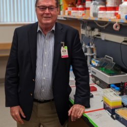 A man in his sixties standing in a medical laboratory.