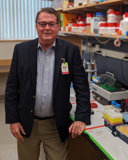 A man in his sixties standing in a medical laboratory.