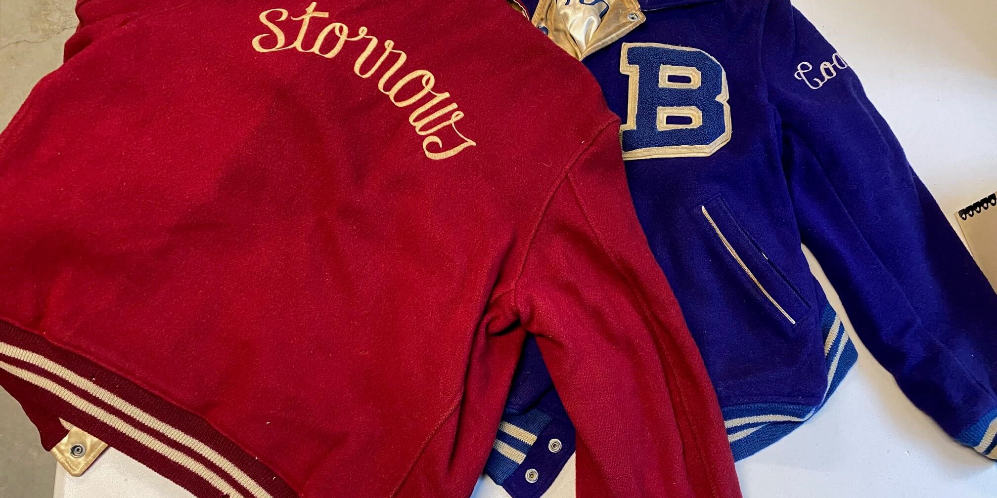 2 varsity jackets, one red, one blue, with the word Storrows (on red) and a large B (on Blue).