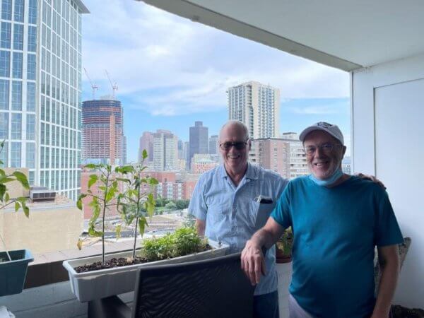 Two men standing in front of a cityscape