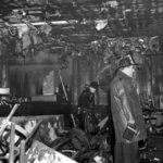 Two fireman standing in the rubble of a nightclub