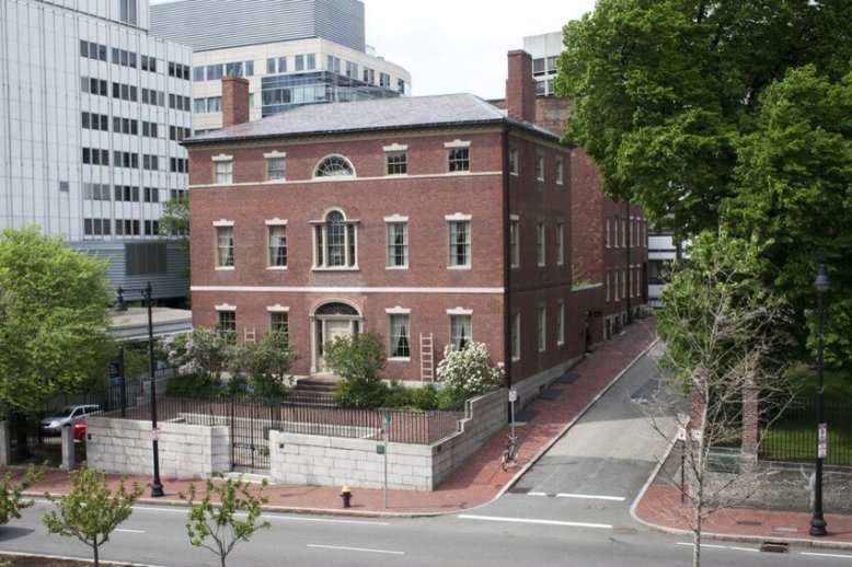 Otis_House_Modern_day Photograph with front oblique view of a three-story brick structure lined with windows on each floor. The building sits on a city street, surrounded by taller more modern buildings.