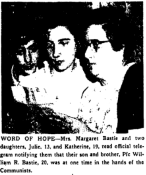 Newspaper photograph of two three women, two younger on left and older on right wearing glasses. All are reading a document together.