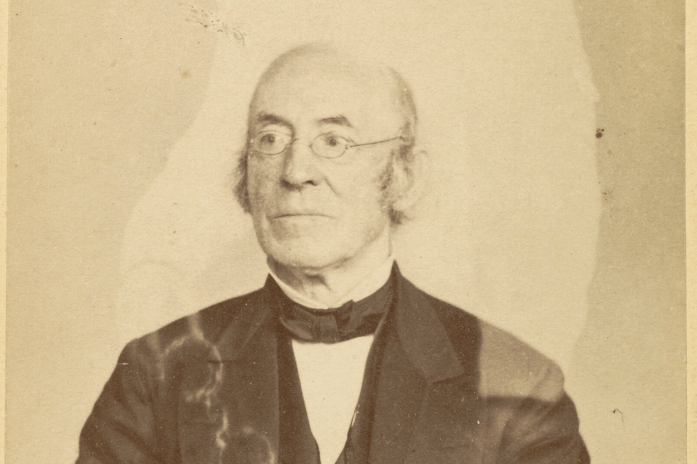 Mumler, Garrison A man sits for a portrait with the faint outline of a person behind him.