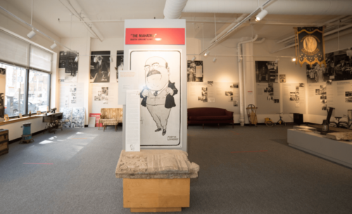 Photograph of museum space with didactic panels and artifacts hung on walls.