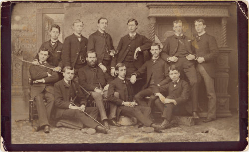 An 1883 sepia-toned photograph showing a group of university boys, some seated and some standing.