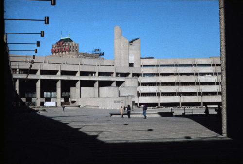 A photograph taken from a center courtyard, showing a large concrete building with variegated levels.