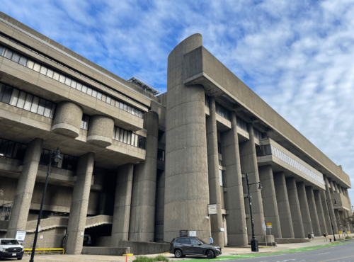 An image of a large concrete building with columns.