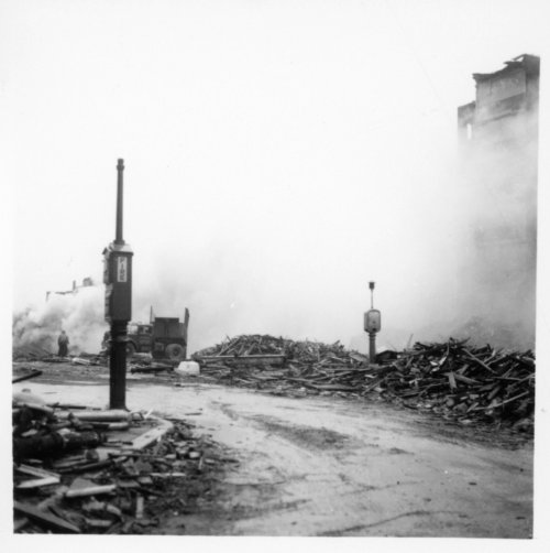 A black and white photograph of a firebox surrounded by rubble and smoke.