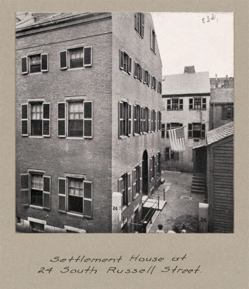 A black and white photograph of a four-story brick building, labelled "Settlement House at 24 South Russell Street."