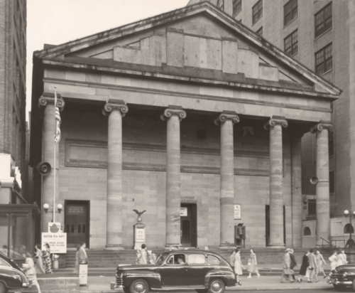 A black and white photograph of a granite, neoclassical church.