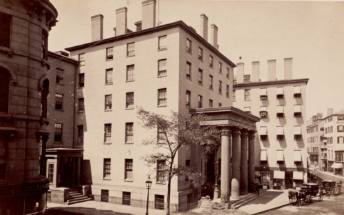 A sepia-toned photograph of a 6-story neoclassical building.