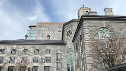 A photograph of a large granite building, with a more modern brick one rising above it, labelled "Liberty Hotel."