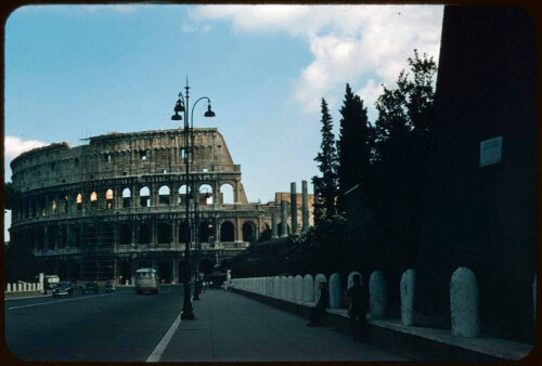 Photograph of a street with the ruins of the Roman Colosseum in the background.