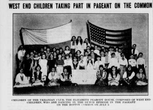 A photograph of many children holding up flags of the US and Ukraine.