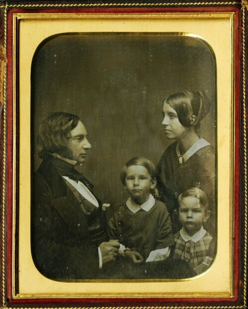 A black and white photo of a man and a woman in profile with two young boys facing the camera.