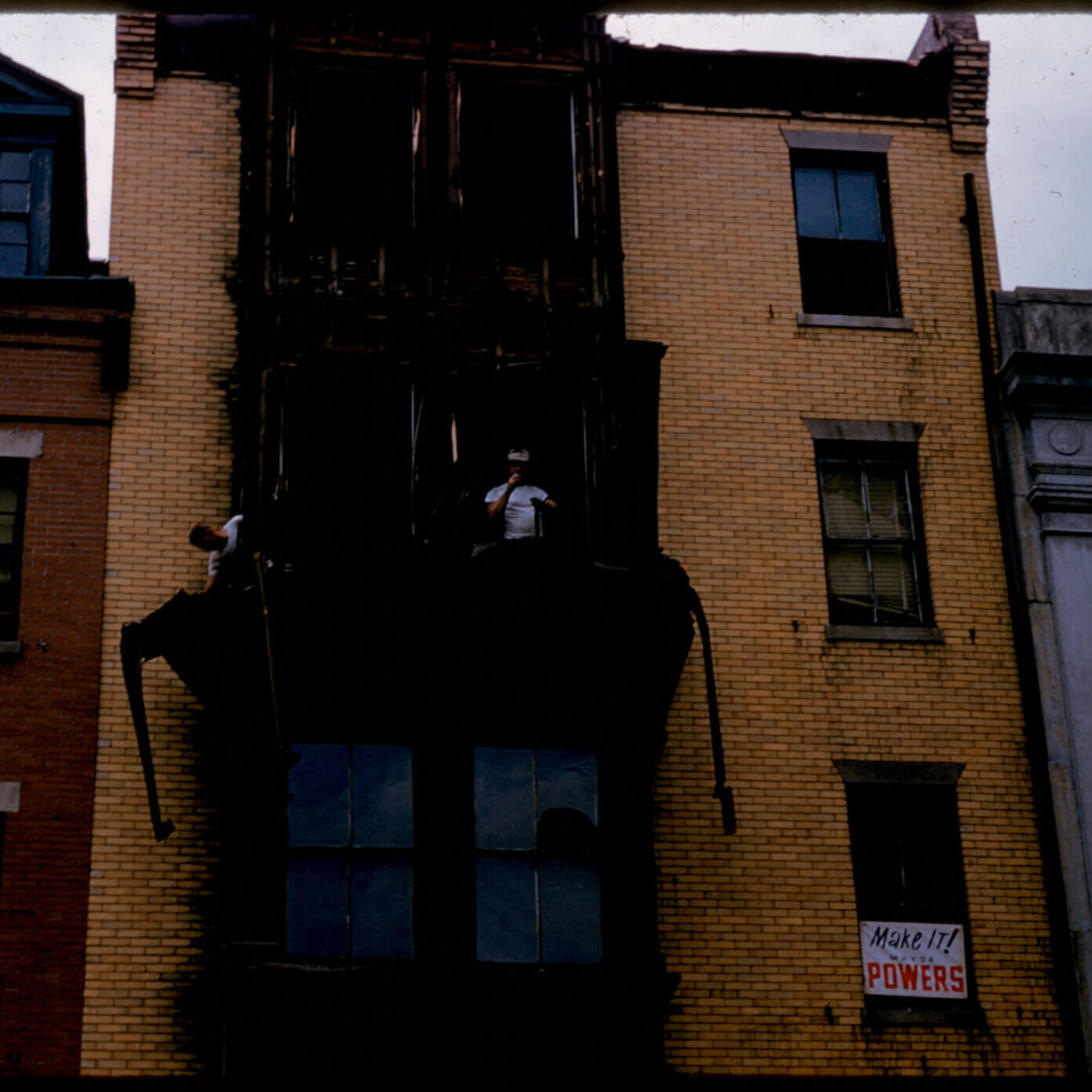 An image of a yellow brick building with fire damage.