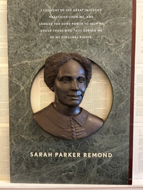 Bronze sculpture bust of a woman in a green marble fram.