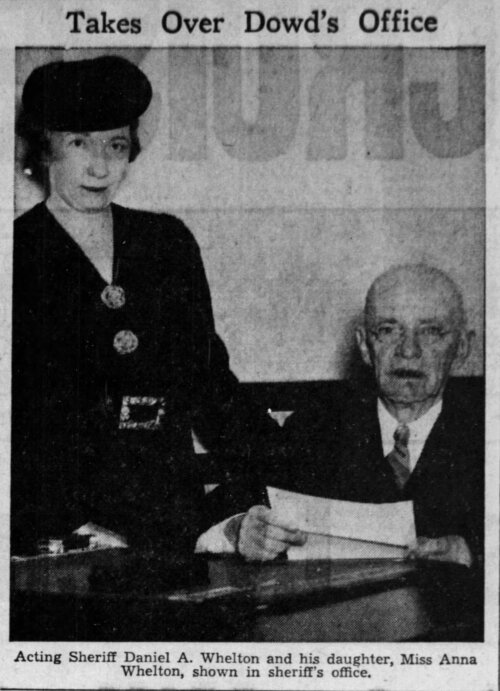 Image of an elderly man seated and a woman in a hat standing next to him.