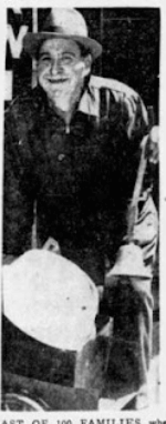 A black and white image of a man moving a box of his things.