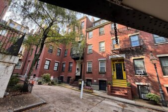 Brick buildings taken from under a low bridge.