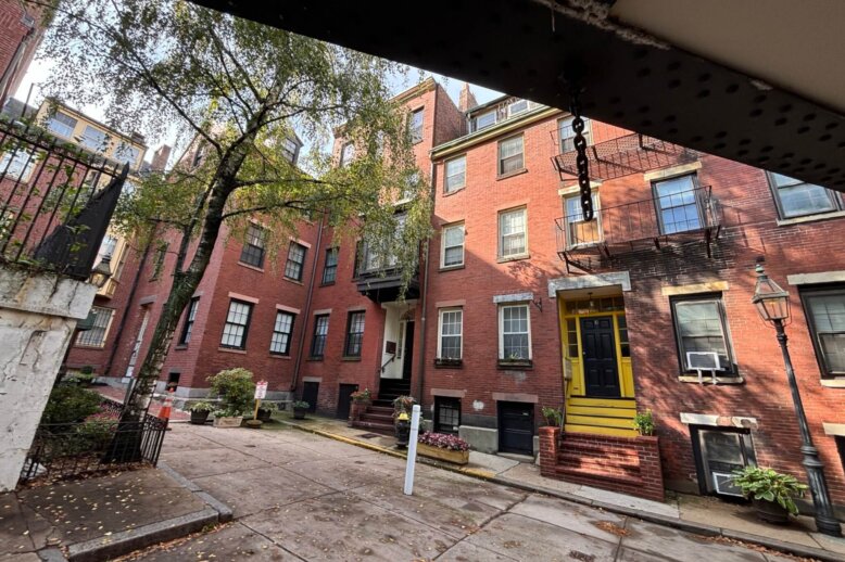 Brick buildings taken from under a low bridge.