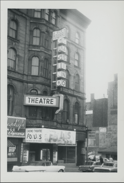 An image of a theatre and marquee with cars in front.