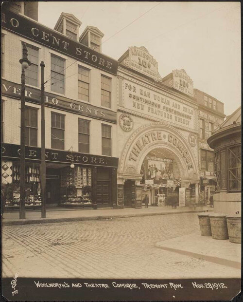 Two buildings on a cobbled street. One is a theatre, the other is a 10 cent store.