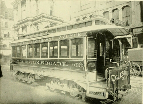An electrified trolly car on a street.