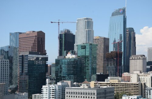 A recent photo of a city with many skyscrapers and a crane.