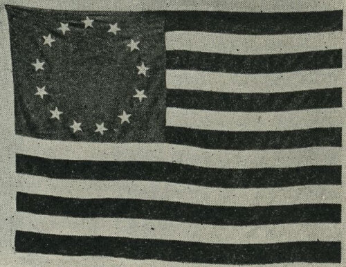 A black and white American flag with thirteen stars in a circle.