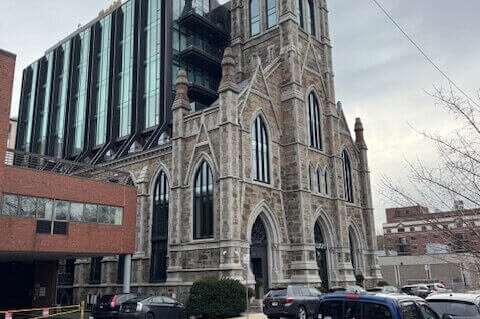 A gothic style church with a short glass tower rising from the nave.