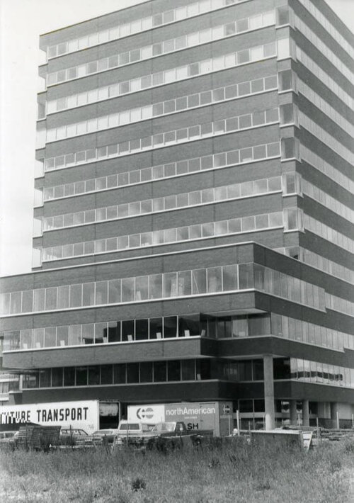A two tiered office building with a moving truck in front.