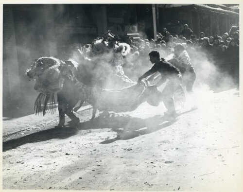 A group of lion dancers on a dusty street.