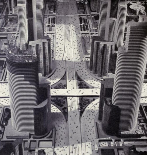 A model of a futuristic city with many tall towers over a complex of highways.