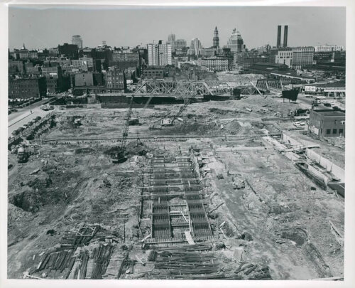 A view looking down on a construction site with large metal piles in the lower half.