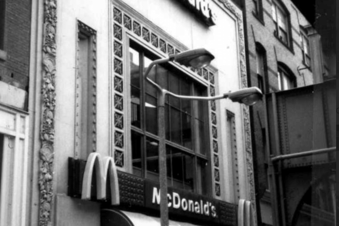 The front of a McDonald's restaurant with a large picture window over the awning.