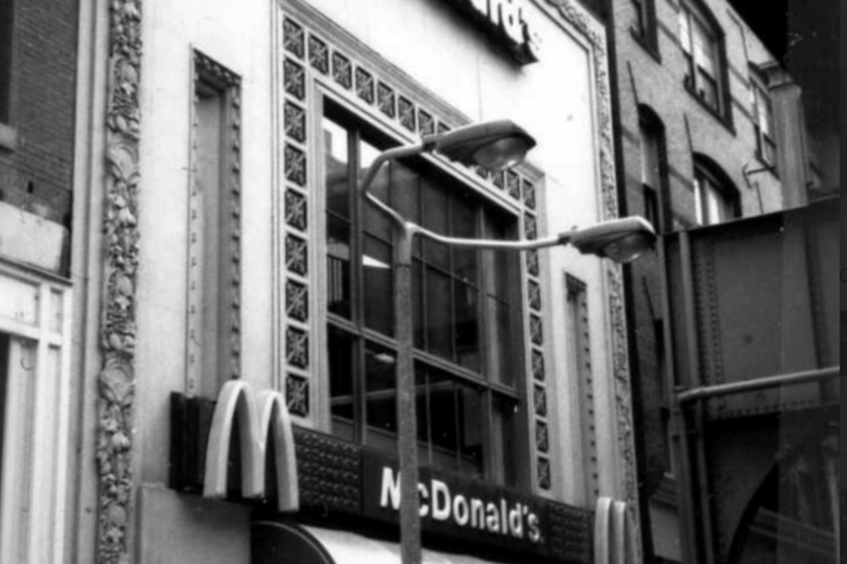 The front of a McDonald's restaurant with a large picture window over the awning.